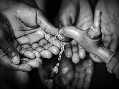 Hands looking for water from a tap. Climate change is responsible for increasing water scarcity