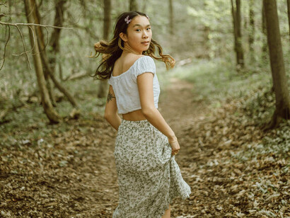 A girl in a dress running into the forest