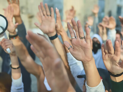 Closeup of crowd of protesters with arms raised demonstrating on the streets