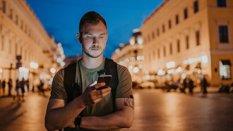 A tourist man walking while checking his social media during his trip