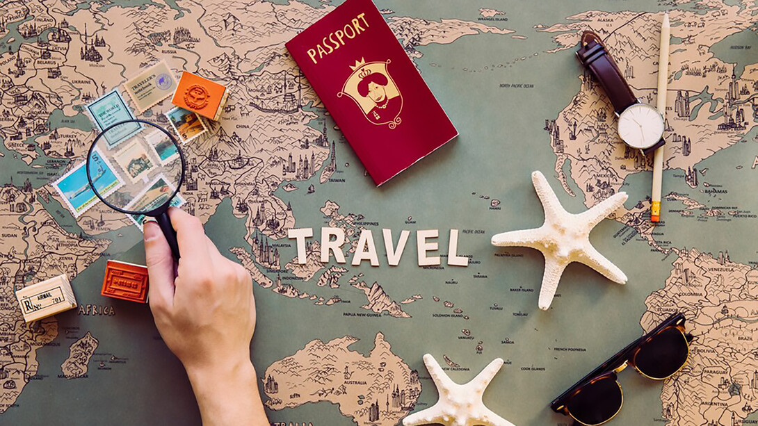 Capture attention with a cropped image of a hand holding a magnifying glass over stamps