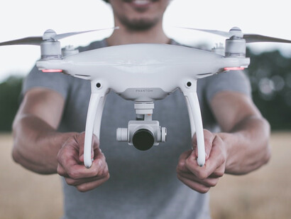 Man holding white and gray drone controller