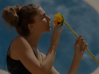 Capturing the essence of self-reflection and personal growth, a woman poses gracefully with a round mirror and flower, radiating inner peace