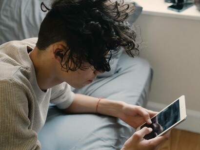 Man uses phone in bed