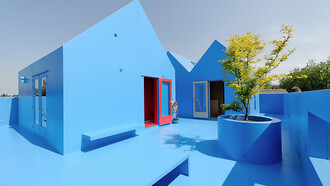 Didden Village in Rotterdam, Netherlands, uses vivid blue forms to create a symbolic rooftop landscape that blends architecture with imagination