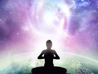 A woman sits in peaceful meditation, her back to the viewer as she contemplates the boundless universe stretching out before her