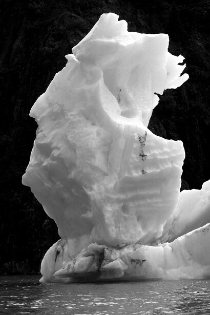 Iceberg flotando sobre el agua cerca del acantilado