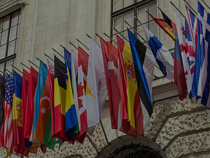 A row of European country flags on a building, representing the Erasmus program and highlighting European identity and EU unity