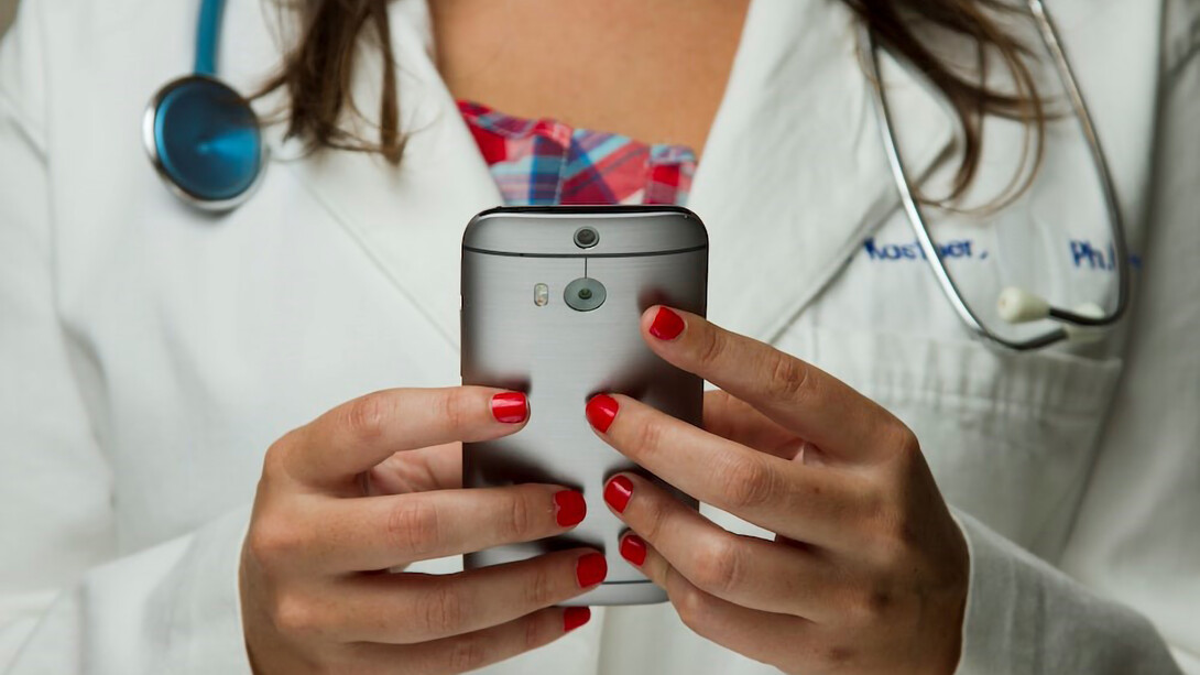 Envision a nurse gracefully holding a mobile phone in the image