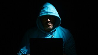 A computer setup with a gaming PC, headphones, and a smartphone on the desk