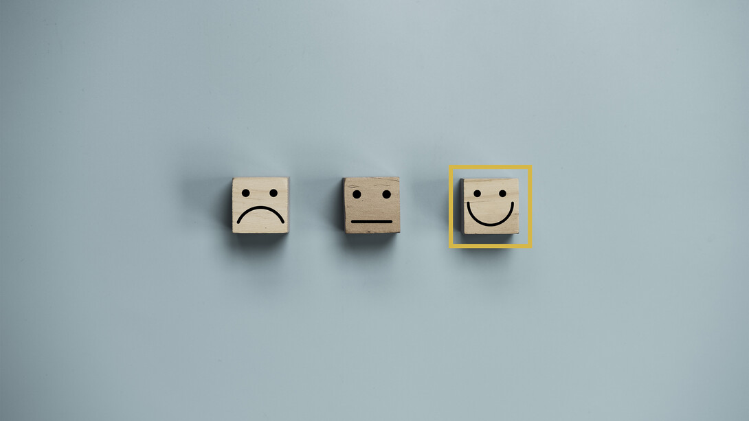 Three emoji faces: a sad face, a neutral face, and a happy face, with the happy face selected