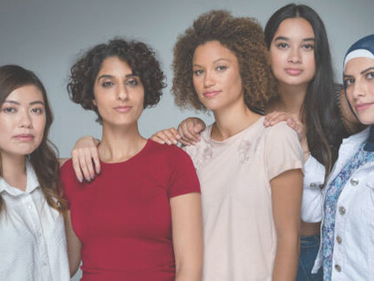 A diverse group of women from various cultural backgrounds standing together, posing in unity