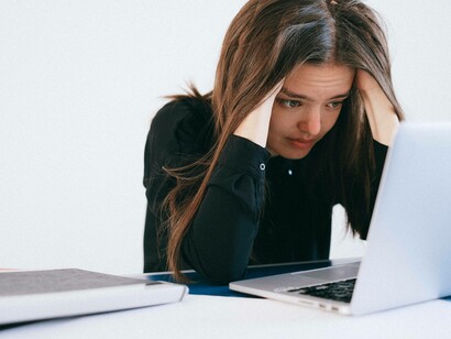 A woman managing her stress levels by running her hands through her hair