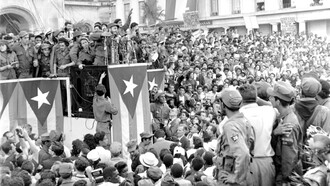 Fidel Castro discursa diante de uma multidão em frente ao palácio presidencial em Havana, Cuba, comemorando a vitória da Revolução Cubana, em 1959. O artigo revisita criticamente o comunismo, as esquerdas e as epistemologias do Sul, distinguindo os conceitos filosóficos e políticos das diferentes experiências históricas que marcaram os séculos XX e XXI. A fotografia evoca um dos processos revolucionários mais influentes do século XX, tema que o artigo aborda ao refletir sobre comunismo, esquerda e projetos de transformação social
