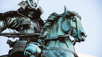 A statue of a man riding a horse, depicting a samurai in traditional Japanese armor