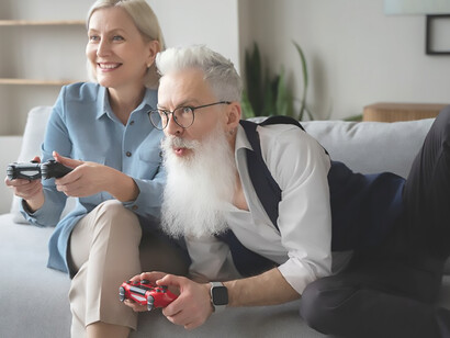 An elderly couple joyfully engaging in video game play, demonstrating that age is no barrier to embracing modern forms of entertainment and shared enjoyment