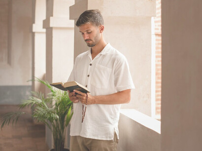 A young man deep in prayer, contemplating religion and creed