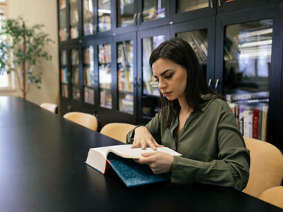 Mujer estudiando en una biblioteca pública