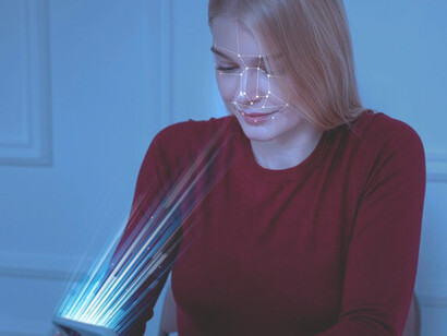 A woman utilizing facial recognition technology on her smartphone