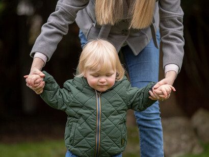 Parents walking with their adorable child in the park, emphasizing individuality, self-expression, and autonomy