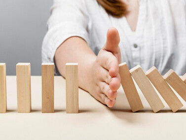 Woman preventing wooden pieces from falling, symbolizing the process of learning from mistakes, self-discovery, and personal growth