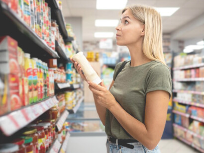 Female shopper meticulously compares product labels while searching for the perfect item in-store