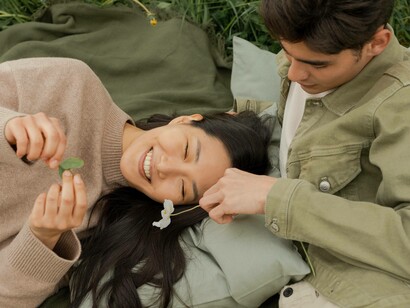 Man holds flower as his date smiles