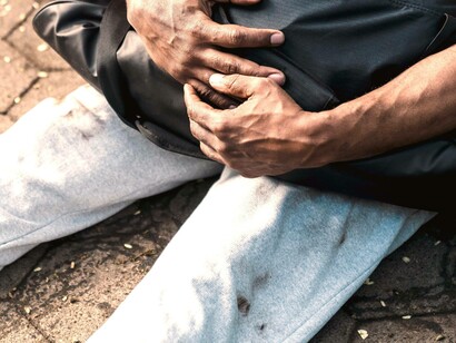 Homeless man gripping his belongings