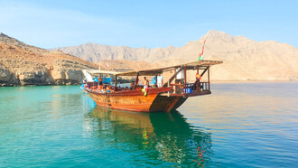 A group of tourists sailing the green waters of Musandam, Oman