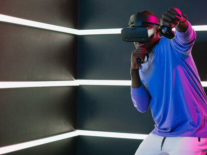 A person fully engrossed in a virtual reality game, experiencing it through a VR headset and cutting-edge technology