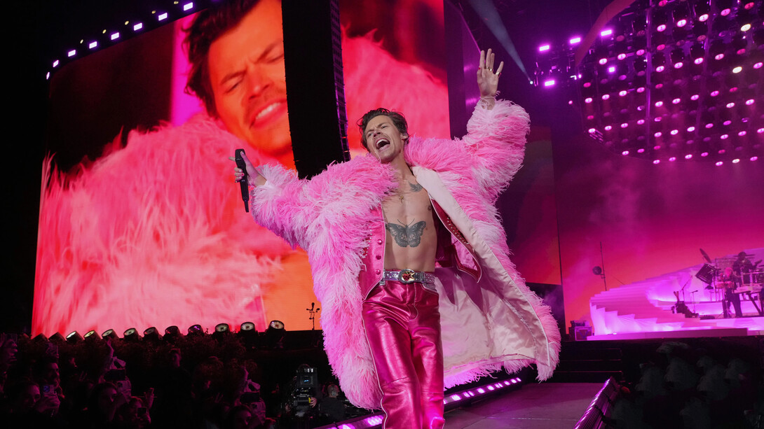 O cantor norte-americano Harry Styles em seu show nos Estados Unidos vestindo peças de paetê e casaco rosa