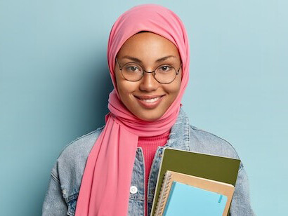Hijabi woman with books, emphasizing the value of education in Islam