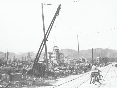 A man pushes his bicycle through the streets after the atomic bomb destroyed Hiroshima, Japan in 1945