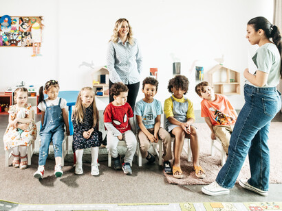 Two female teachers teaching seven young learners in school