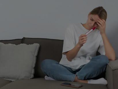 A poignant image depicts a woman grappling with infertility, her emotions laid bare as she holds a negative pregnancy test