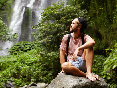 As the waterfall flows in the background, he embraces the calming power of meditation, allowing his thoughts to settle into stillness