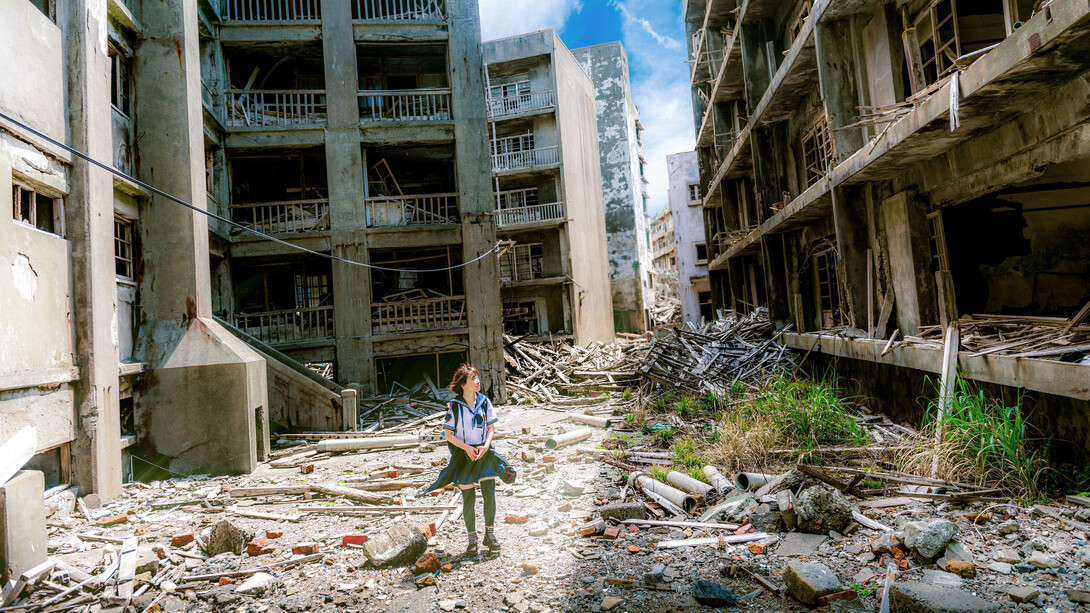 A girl walks amidst a wrecked and war torn city
