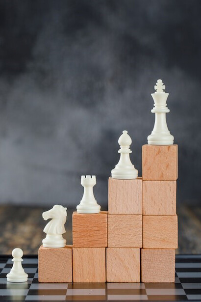 Business hierarchy concept: a chessboard, wooden figures, and a pyramid of blocks on a foggy wooden table, symbolizing strategic growth and leadership