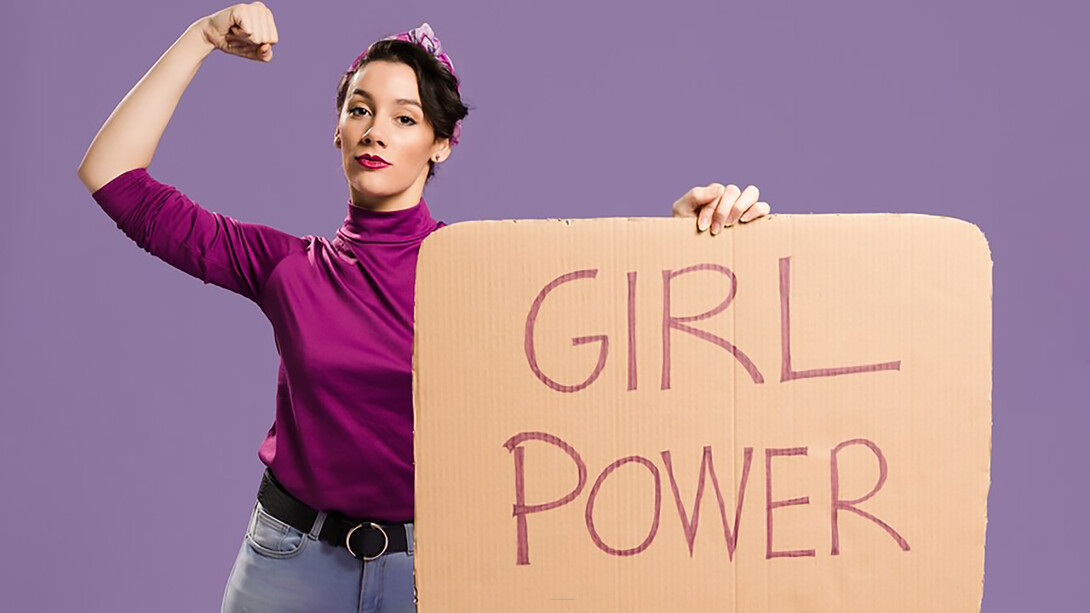 Girl power message on a cardboard sign held by a woman