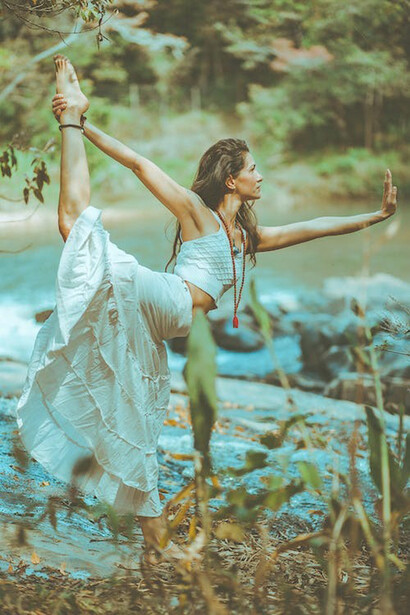A woman, embracing the wisdom of an Ayurvedic lifestyle, finds serenity and connection with nature, gracefully standing on one foot