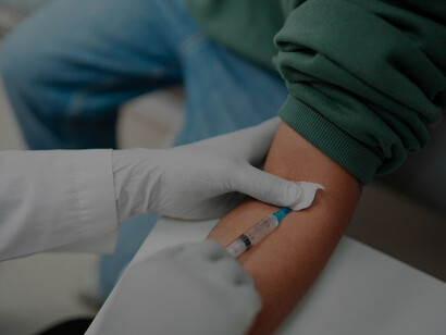 In a medical setting, a skilled doctor is depicted collecting a blood sample from a patient, emphasizing the critical role of diagnostic procedures in comprehensive healthcare practices