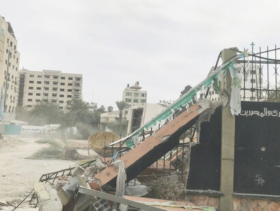 A pile of rubble beside a building covered in graffiti captures the devastation in Gaza following the bombing by the State of Israel that began on October 7, 2023