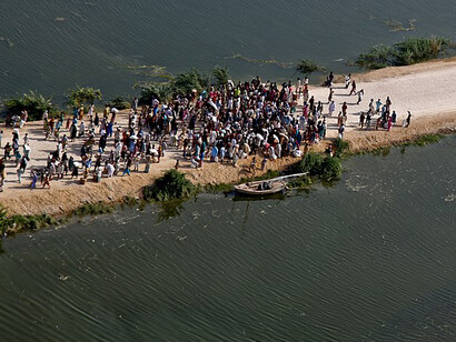 An aerial view of Pakistani flood survivors isolated on a road surrounded by water, Pakistan
