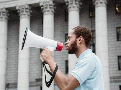 A protestor with a megaphone organizing the mass of protestors