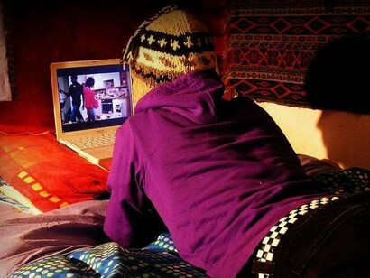 Adolescente viendo una película en su ordenador