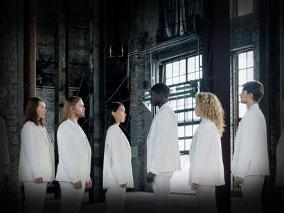 People standing together wearing white suits facing each other