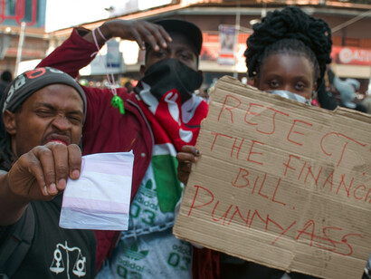 Kenyan youths chanting and holding flags at a vigil for protesters killed in nationwide demonstrations