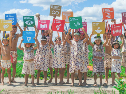Peruvian children from the Amazon River hold up signs of each of the sustainable development goals