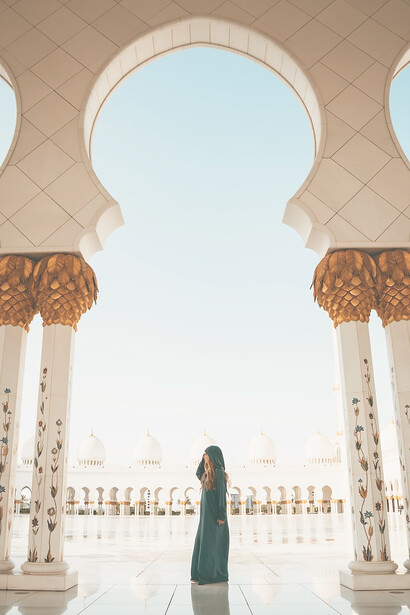 A woman wearing a hijab explores the Grand Mosque North Parking Lot in Abu Dhabi, United Arab Emirates
