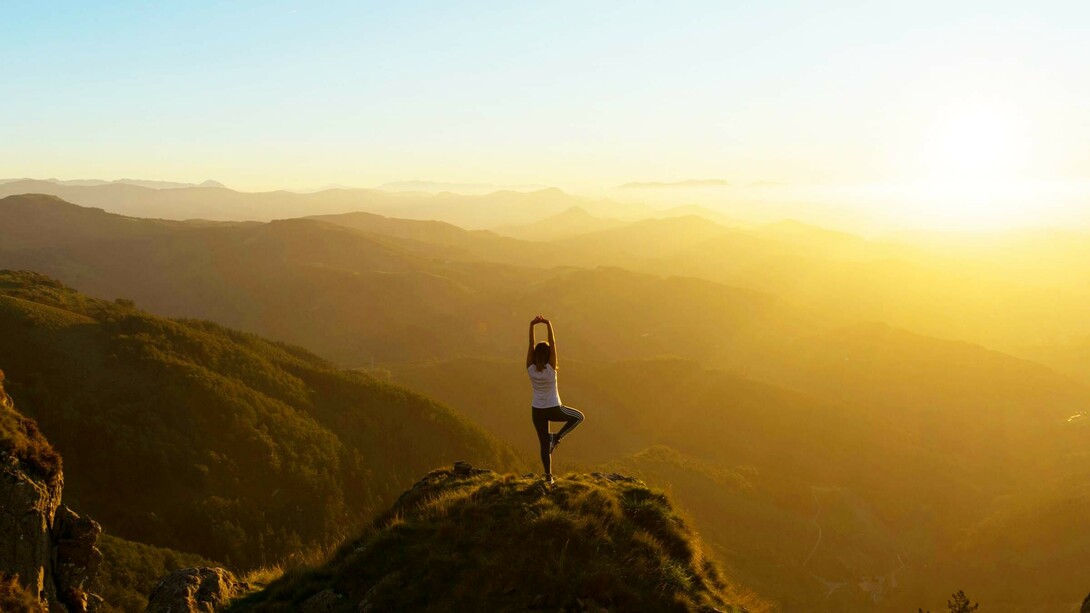 A meditation enthusiast doing yoga on a cliff and enjoying the spiritual freedom and physical strength it brings